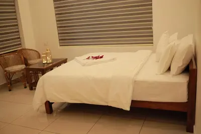 a bed with white sheets and red flowers on it at Humblebee Retreat Tattekkad in Kuttampuzha