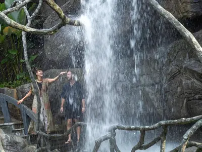 two men standing in front of a waterfall at The Grand Cliff Resort Munnar in Viripara