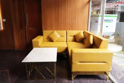 a yellow couch and a coffee table in a room at LUXIE INN MALABAR in Perintalmanna