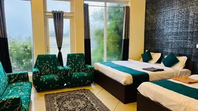 a bedroom with two beds and a couch and a window at Hidden heritage ins in Ooty