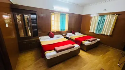 a bedroom with two beds and a mirror at Hidden heritage ins in Ooty