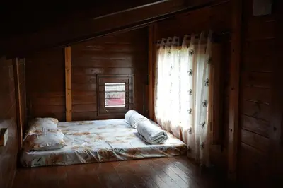 a bed in a wooden room with a window at labdhi Resorts Masinagudi- Stag Groups not allowed in Masinagudi