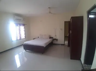 a bedroom with a bed in a room with a window at Renu Residency near Maruthamalai and on the way to Adiyogi Isha yoga Centre in Marudhamalai
