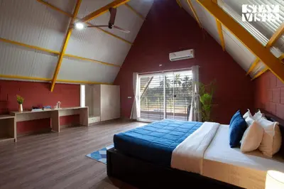 a bedroom with a large bed and a window at Golden Apex by VEO - Part of StayVista in Hampāpura