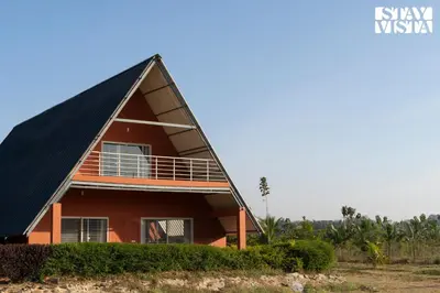 a house with a triangular roof at Golden Apex by VEO - Part of StayVista in Hampāpura