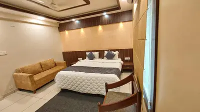 a bedroom with a bed and a couch in a room at Hotel Royal Wings in Elūr
