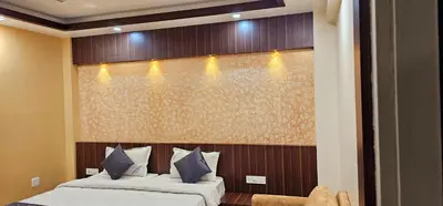 a bedroom with two beds and a large wall at Hotel Royal Wings in Elūr