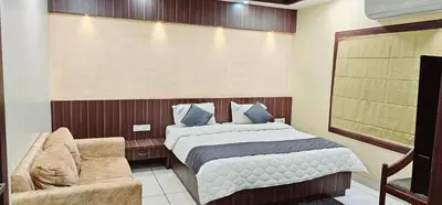 a bedroom with a bed and a chair at Hotel Royal Wings in Elūr