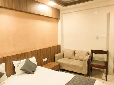 a bedroom with a bed and a chair at Hotel Royal Wings in Elūr