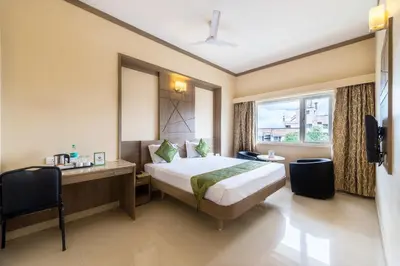 a hotel room with a bed and a desk and a window at Treebo ESS Grande in Coimbatore
