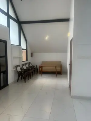 a hallway with chairs and a table in a building at Feel Free Retreat in Kalpetta