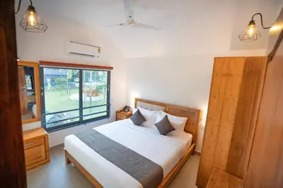 a bedroom with a bed and a large window at Feel Free Retreat in Kalpetta