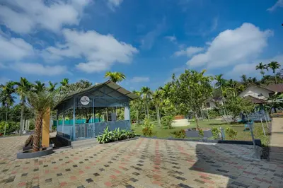 a pavilion at a resort with a palm tree at Feel Free Retreat in Kalpetta