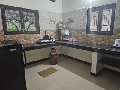 a kitchen with a counter top and a refrigerator at SHI's Velliangiri 3BHK Individual villa Near Isha Adiyogi, Coimbatore in Alāndurai