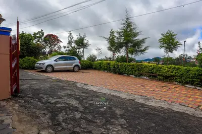 a silver car parked in a parking lot at Vijaya Deepa Guest House by LexStays in Coonoor