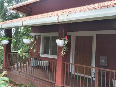a porch of a house with a balcony at Coorg klusters estate stay in Virajpet