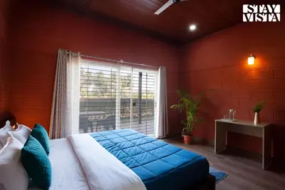 a bedroom with a large bed and a window at Golden Triangle by VEO - Part of StayVista in Hampāpura