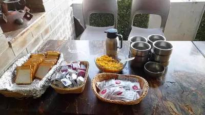 a table with baskets of bread and other food on it at Hotel Roopa in Mysore