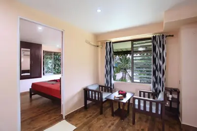 a bedroom with a bed and a table and a mirror at Elephant Pass Ayurveda & Yoga Retreat in Malayāttūr