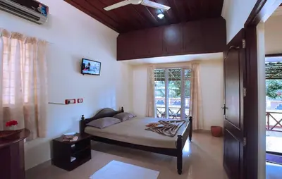 a bedroom with a bed and a window at Elephant Pass Ayurveda & Yoga Retreat in Malayāttūr
