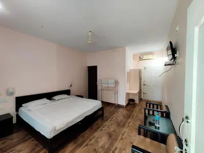 a bedroom with a large white bed in a room at Elephant Pass Ayurveda & Yoga Retreat in Malayāttūr
