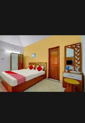 a hotel room with a bed and a desk and a bed sidx sidx at HILL BIRD HOME STAY Ooty in Ooty