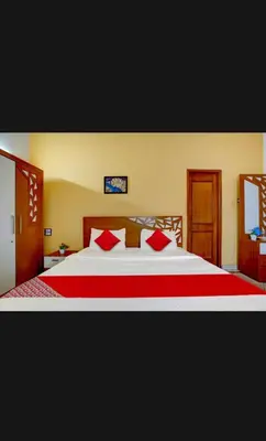 a bedroom with a large bed with red pillows at HILL BIRD HOME STAY Ooty in Ooty