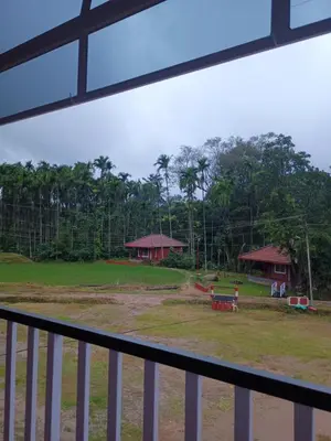 a view of a park from a balcony at Nature Spot Cottages Coorg in Kurchi