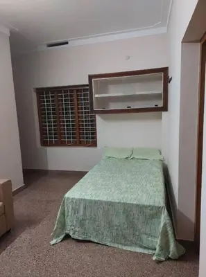 a small bedroom with a bed and a window at Homestay Guruvayur, 2 AC Bedrooms, Hall, Veranda, Kitchen in Guruvāyūr