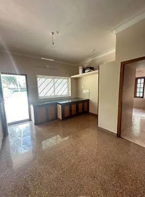 a large empty room with a counter in a building at Homestay Guruvayur, 2 AC Bedrooms, Hall, Veranda, Kitchen in Guruvāyūr