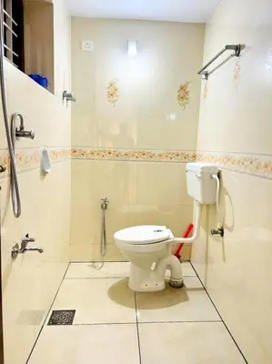 a bathroom with a toilet and a shower at Guruvayur Homestay - 2 AC Bedrooms, Hall & Veranda in Guruvāyūr
