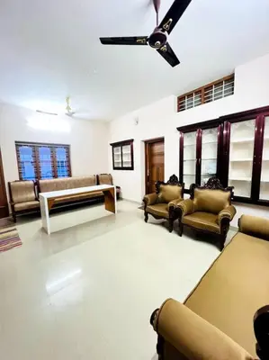 a living room with couches and a ceiling fan at Guruvayur Homestay - 2 AC Bedrooms, Hall & Veranda in Guruvāyūr