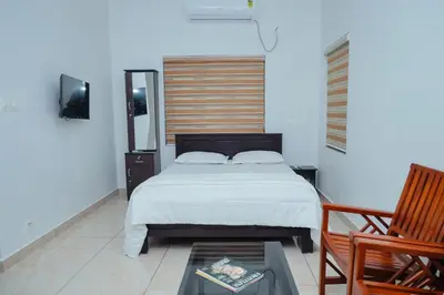 a bedroom with a bed and a table and a chair at Sankalpa Homestay in North Paravur