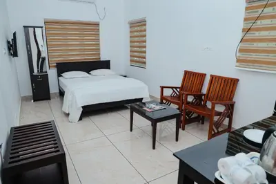 a bedroom with a bed and two chairs and a table at Sankalpa Homestay in North Paravur