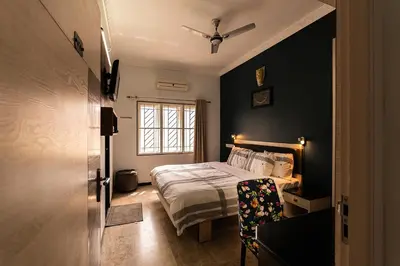 a bedroom with a bed and a window at Hive Service Apartment in Coimbatore