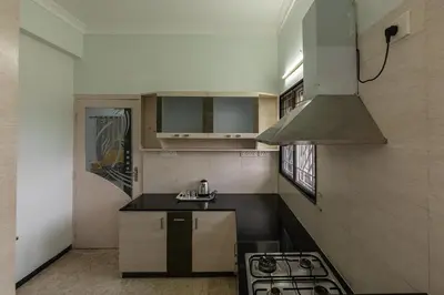 a small kitchen with a stove and a sink at Hive Service Apartment in Coimbatore