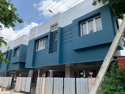 a blue and white building with a fence in front of it at Hive Service Apartment in Coimbatore