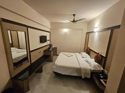 a bedroom with a bed and a large mirror at HOTEL MERILIN in Erode