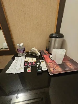 a tray with a coffee maker and remote controls on a table at HOTEL MERILIN in Erode