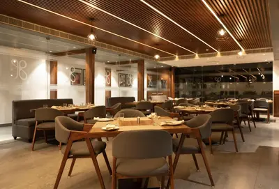 a restaurant with tables and chairs in a room at Gokulam Park Guruvayur in Guruvāyūr