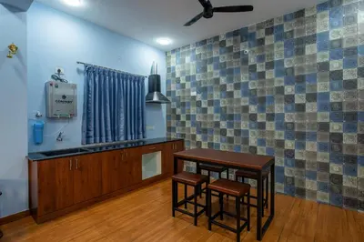 a kitchen with two stools and a table in a room at MUGUNDAN 'S SMART STAY in Coimbatore