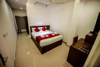 a bedroom with a bed with red pillows at Airport Avenue Plaza in Nedumbassery