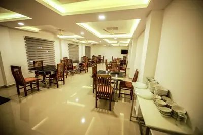 a dining room with tables and chairs in a restaurant at Airport Avenue Plaza in Nedumbassery