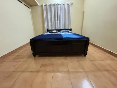 a bedroom with a bed with a blue mattress at Kokaris Coorg Homestay in Kushālnagar