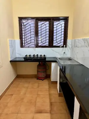 a kitchen with a counter top and a window at Kokaris Coorg Homestay in Kushālnagar