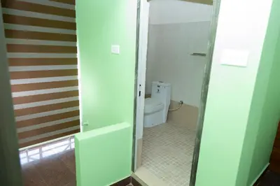 a bathroom with a toilet and a glass shower door at Hamsted in Kottakkal