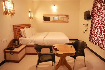 a bedroom with a bed and a table and chairs at The Woodlands Residency- Unmarried and stag groups not allowed in Ooty
