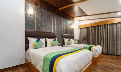 a bedroom with two beds in a room at Treebo Skydale Premium Suites, 1500 Mtrs From Ooty Lake in Ooty