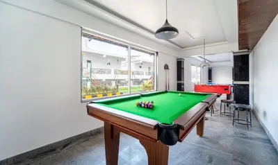 a pool table in a room with a window at Treebo Skydale Premium Suites, 1500 Mtrs From Ooty Lake in Ooty
