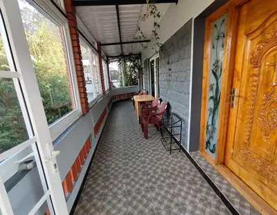 an empty porch of a house with a table and chairs at Pear Tree Entire 2BHK Villa Kotagiri in Kotagiri